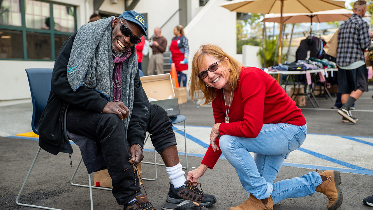 A member helping someone try on shoes